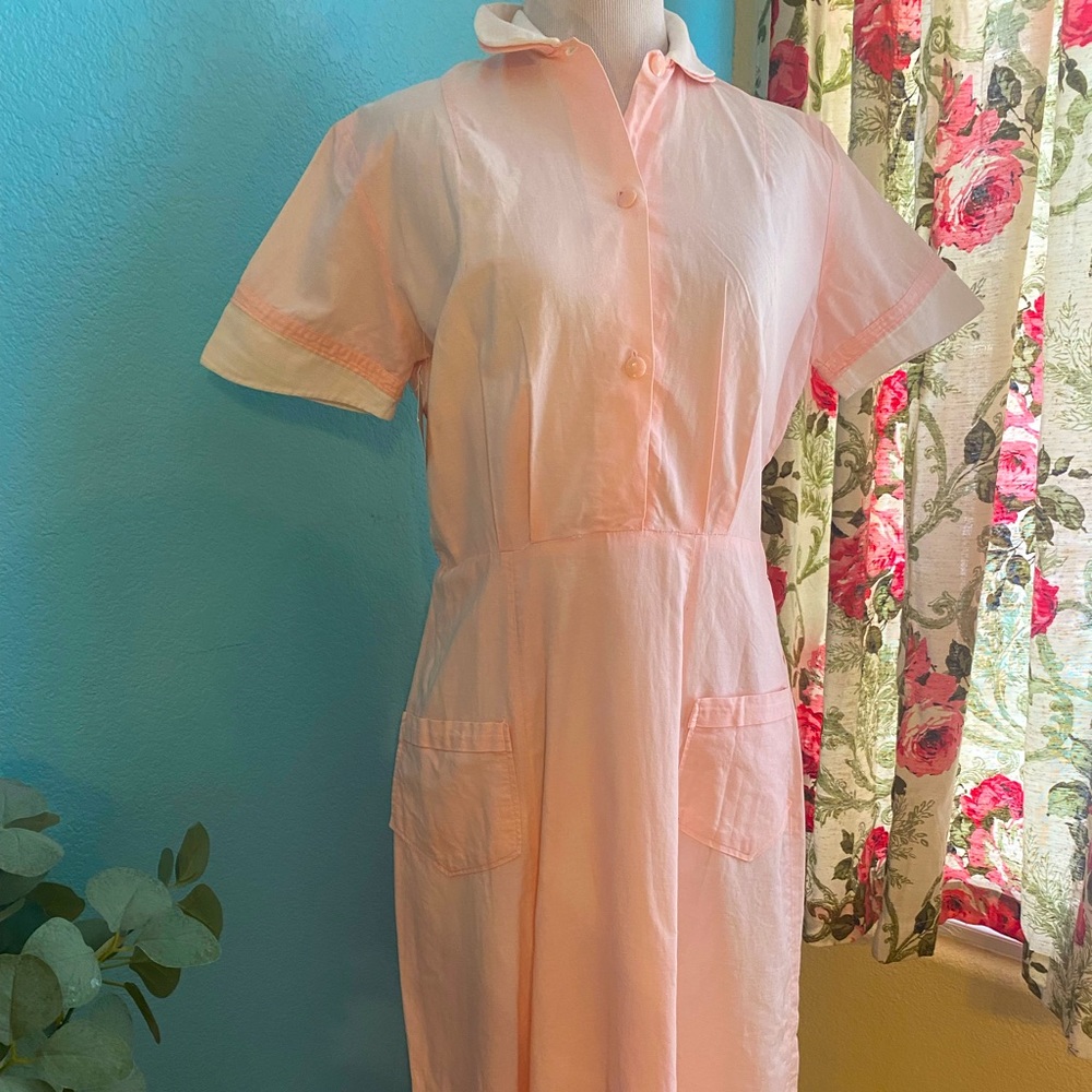 Pink vintage 1950s retro waitress style dress with white trim and button snaps